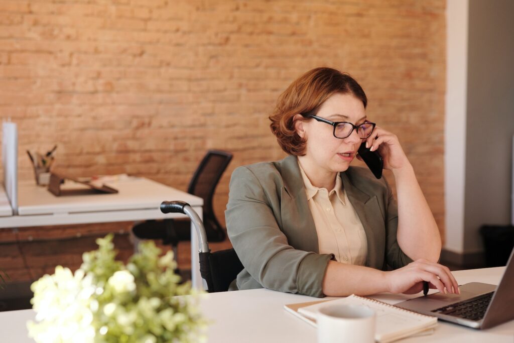Home Office na Construtora Tenda 2023 Photo of Woman Talking Through Smartphone While Using Laptop