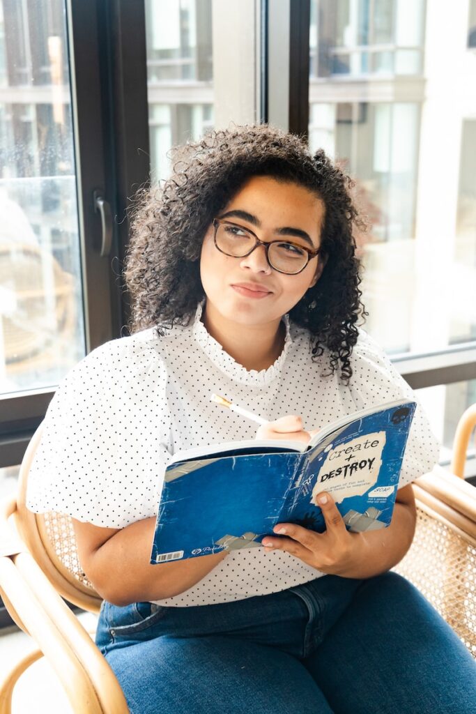 Somos Livres para as Nossas Escolhas? woman in white and black polka dot shirt holding blue and white book