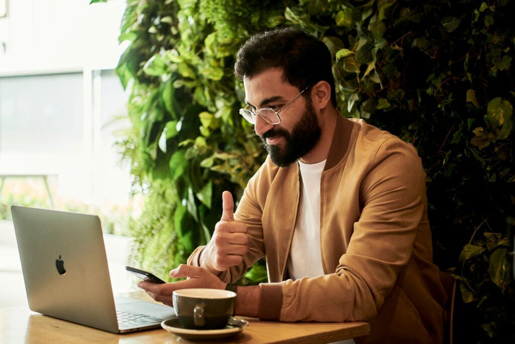 70 vagas de emprego em lojas, indústria e remotas man in brown jacket sitting at a table looking at laptop