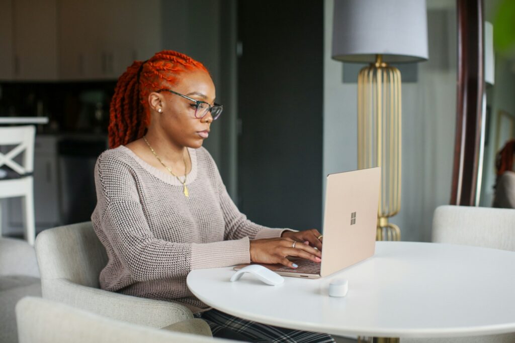 Vagas Remotas em Instituição de Educação woman in gray knit sweater using Surface computer