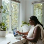 Vagas de Emprego na Hyperativa a woman sitting at a table with a laptop