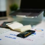 Sudu Tech contratando em São Bernado do Campo office desk with smartphone and financial charts