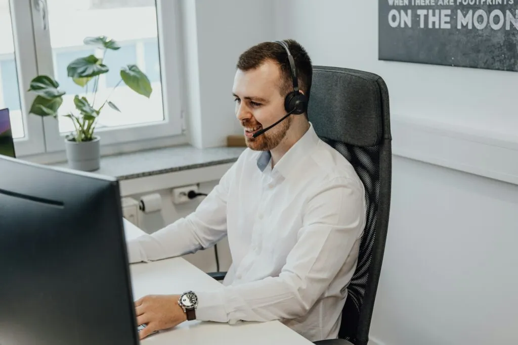Teletrabalho para Operadores de Telemarketing a man wearing a headset sitting in front of a computer
